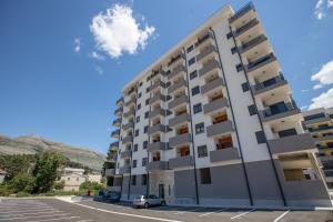 an apartment building in a parking lot at Apartman Solis in Trebinje