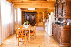 a kitchen with a table and chairs and a refrigerator at Privaatne maja metsas, kraanist voolab allikavesi in Plaani