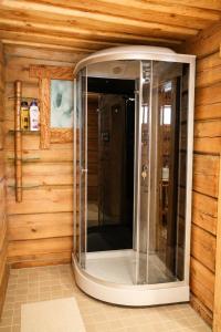 a walk in shower in a room with wooden walls at Privaatne maja metsas, kraanist voolab allikavesi in Plaani +23 photos