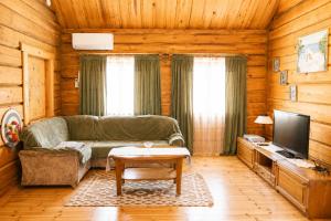 a living room with a couch and a tv at Privaatne maja metsas, kraanist voolab allikavesi in Plaani