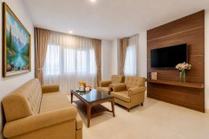 a living room with a couch and chairs and a tv at T78 Luxury Hotel in Ho Chi Minh City