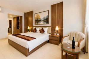 a bedroom with a bed and a table and a chair at T78 Luxury Hotel in Ho Chi Minh City