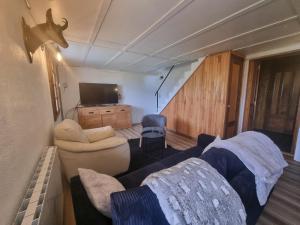 a living room with a couch and a tv at Comfortable Chalet with spectacular mountain views in Verchaix