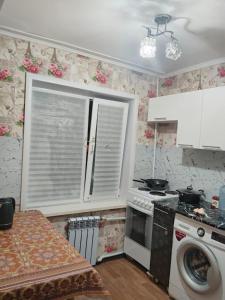 a kitchen with a washing machine and a window at ИП Саялы in Balqash +7 photos