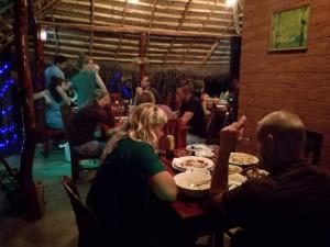 a group of people sitting at a table in a restaurant at Star Light Cabanas & Restaurant in Tangalle