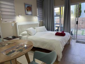 a hotel room with a bed and a table and a table at Withuis Hartenbos - No Load Shedding in Hartenbos