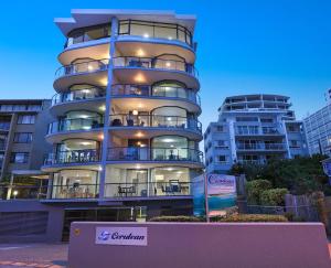 a tall apartment building with a sign in front of it at Cerulean Apartments in Caloundra
