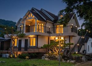 a large white house with lights on it at Gapyeong Yunseul Pension in Chuktul-li
