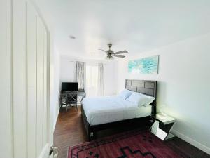 a bedroom with a bed with a ceiling fan and a desk at Hopes Cozy Condo in Phoenix