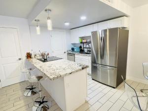 a kitchen with white cabinets and a stainless steel refrigerator at Hopes Cozy Condo in Phoenix