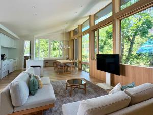 a living room with two couches and a tv at KOMU Hakuba in Hakuba