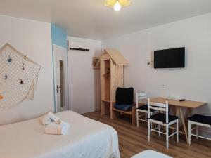 a room with two beds and a table and a television at Hotel Marjolaine in Roullet