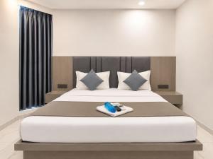 a bedroom with a large white bed with blueippers on it at Hotel Elite in Ahmedabad