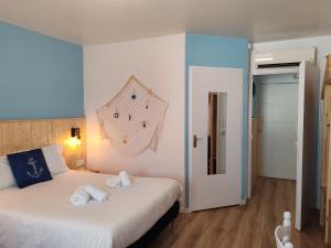 a bedroom with a large white bed with white pillows at Hotel Marjolaine in Roullet