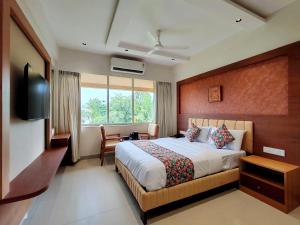 a bedroom with a bed and a flat screen tv at Hotel Sai Residency in Karjat +38 photos