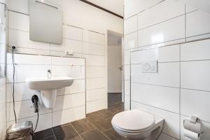 a white bathroom with a toilet and a sink at Haus 50 in Röbel +38 photos