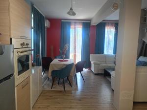 a kitchen and living room with a table and a couch at Къща Уют in Rogachevo