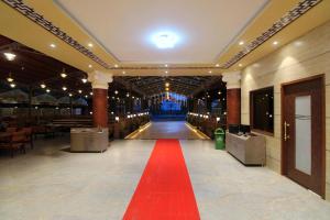a red carpet in the middle of a hall with a red floor at Hotel Sai Residency in Karjat