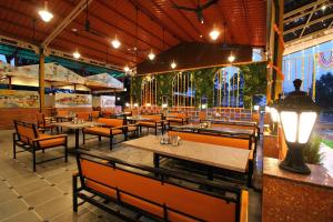 a restaurant with tables and chairs and a lit up room at Hotel Sai Residency in Karjat