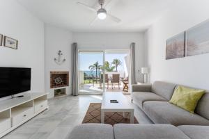 a living room with a couch and a tv at 203 Arruzafa Sea View in Málaga