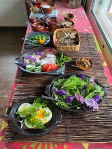 a table topped with plates of food and vegetables at Majatalo Puukarin Pysäkki in Nurmes