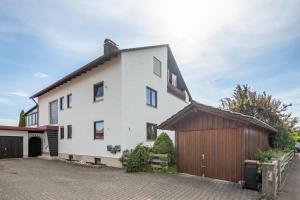 a white house with a brown garage at Ferienwohnung Laura in Illertissen