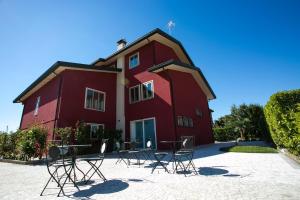 ein rotes Gebäude mit Stühlen und Tischen davor in der Unterkunft Guest House Dolce Laguna in Tessera