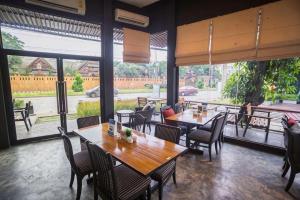 a restaurant with tables and chairs and large windows at MDR Hotel in Ban Sa Maklua