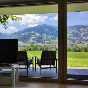 a room with two chairs and a view of a mountain at Apart Loris in Hart im Zillertal