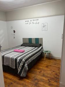a bedroom with a bed with a sign on the wall at Willow whispers in Gqeberha