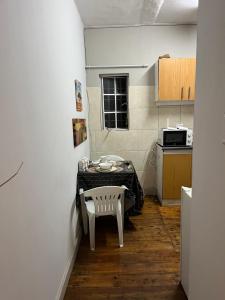 a small kitchen with a table and a chair at Willow whispers in Gqeberha