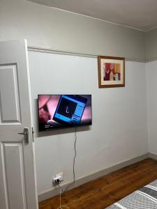 a flat screen tv hanging on a wall at Willow whispers in Gqeberha