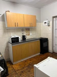 a kitchen with wooden cabinets and a microwave at Willow whispers in Gqeberha +4 photos