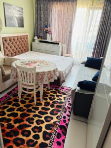 a bedroom with a bed and a table and a couch at ADMIRAL PLASA studiyo-25C in Sunny Beach
