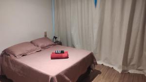 a bed with a red box on top of it at Lagoa Flats com Super Varanda in Lagoa Santa