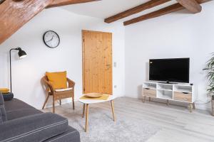 a living room with a couch and a tv at Winzerhof Nagel in Dettelbach