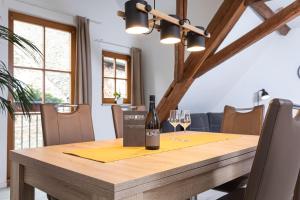 a bottle of wine on a wooden table with glasses at Winzerhof Nagel in Dettelbach +15 photos