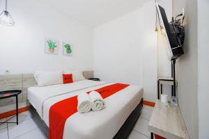 a bedroom with a bed with two towels on it at RedDoorz near Mangga Dua Mall in Jakarta