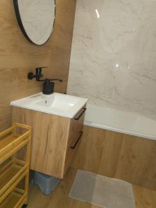 a bathroom with a sink and a bath tub at Apartament Kaszmirowy in Gorlice +37 photos