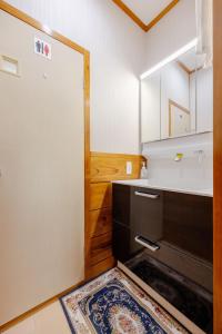 a kitchen with a sink and a door with a rug at ジャポニークハウス in Sanmu +66 photos