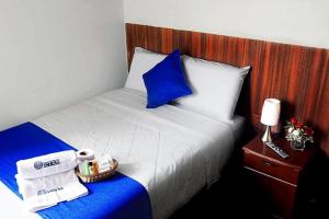 a hotel room with a bed with blue and white sheets at Hotel Inkas in Arequipa