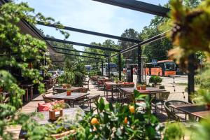 eine Terrasse mit Tischen, Stühlen und Pflanzen in der Unterkunft Gabija Hotel SPA & Conferences in Palanga