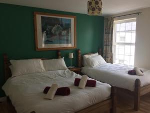 2 camas en una habitación con paredes verdes en Roomz en Portaferry