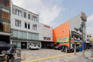 a group of buildings on a street with parked cars at RedDoorz near Mangga Dua Mall in Jakarta