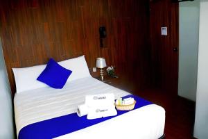 a bed with a blue pillow and towels on it at Hotel Inkas in Arequipa