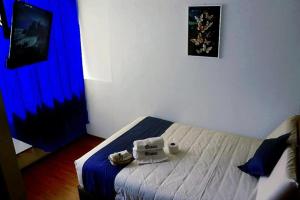 a bedroom with a bed with a blue curtain at Hotel Inkas in Arequipa +3 photos