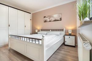 a bedroom with a large white bed and white cabinets at Haus 7 in Röbel