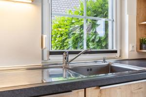 a kitchen with a sink and a window at Haus 7 in Röbel +29 photos