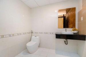 a white bathroom with a toilet and a sink at Simpsons homestay - Oasky 36 #viewtamthang #viewbien #vungtau in Xã Thang Tam +22 photos