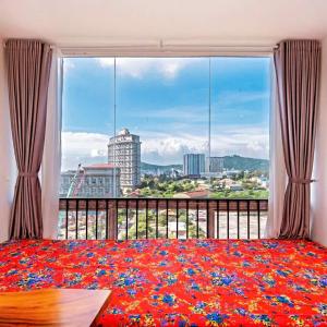a bedroom with a large window with a view of a city at Simpsons homestay - Oasky 36 #viewtamthang #viewbien #vungtau in Xã Thang Tam